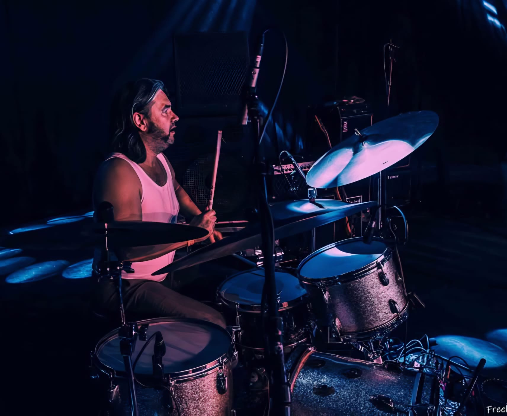 Johan van Lanen speelt drum op een donker podium